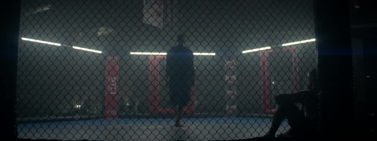 A man walks in a fighting cage