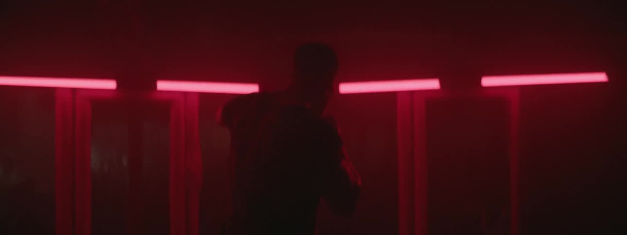 A man shadow boxes in a neon lit gym