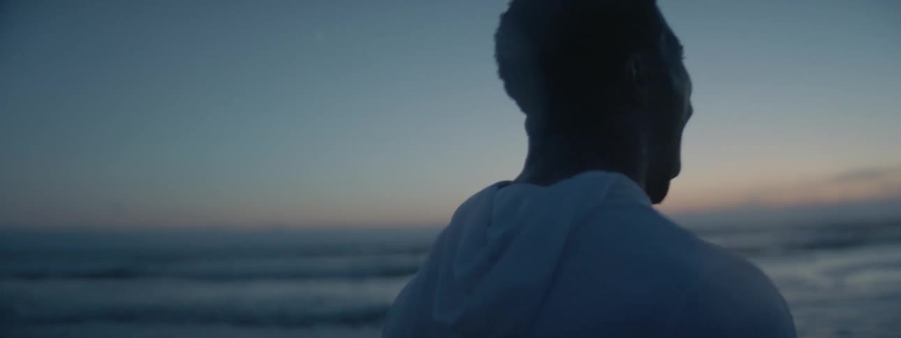 A man is standing on the beach screaming