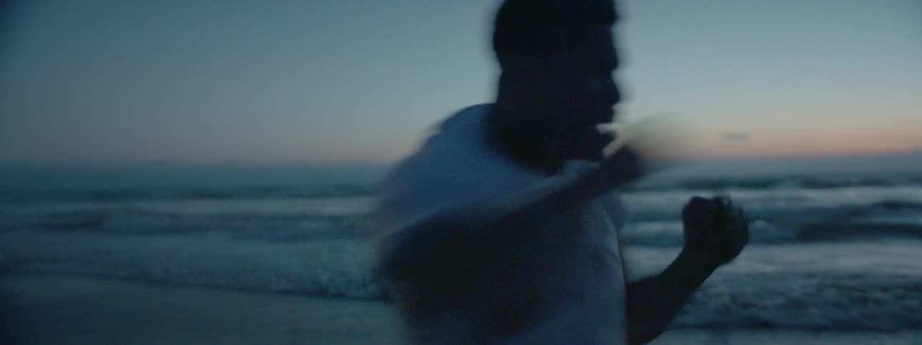 A man spars on a beach at dusk