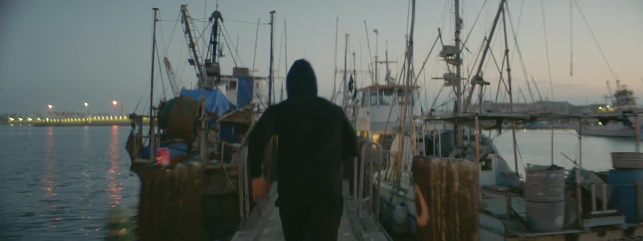 A man jogs on the wooden pier at dawn
