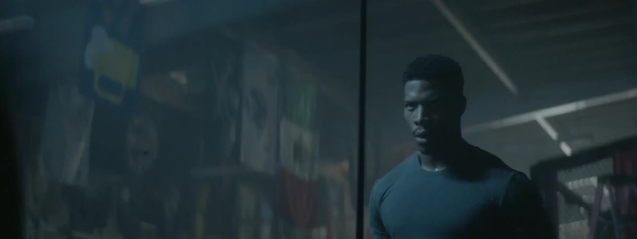 A man trains in a gym with weights in front of a mirror