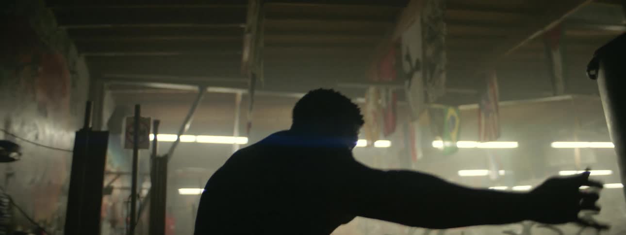 A man practices his kicks against a bag in the gym