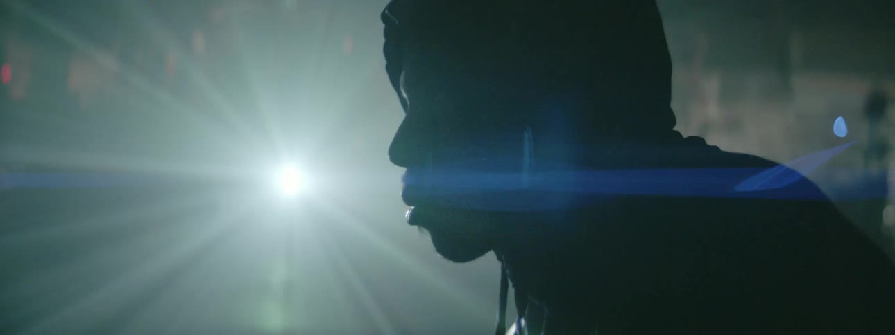 A man stands in front of a bright light