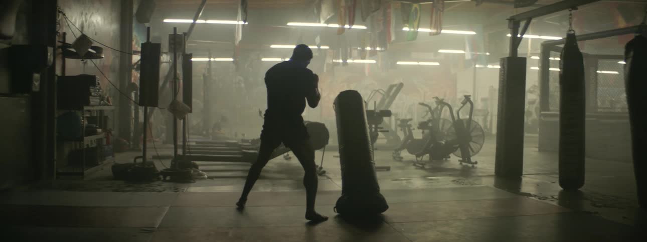 A boxer hits a punching bag in a gym