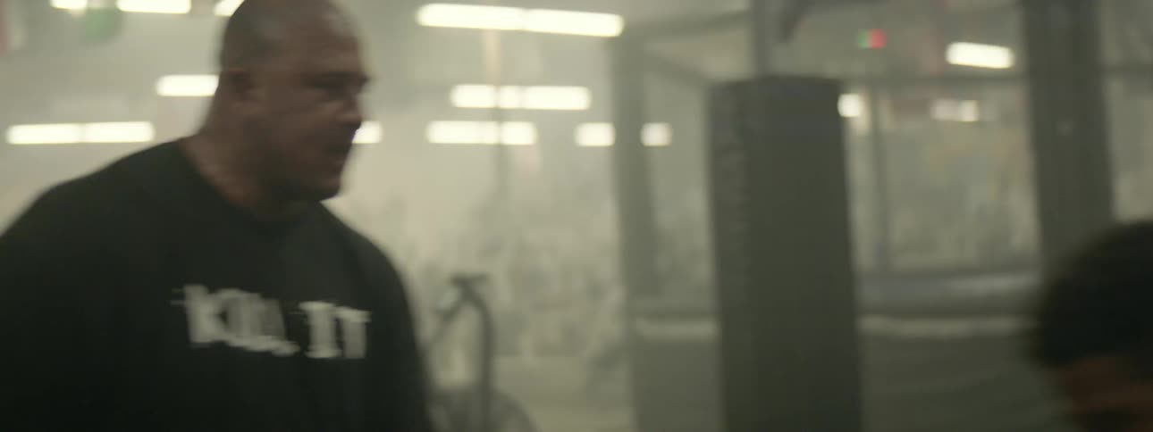 A man is practicing his kickboxing skills in the gym