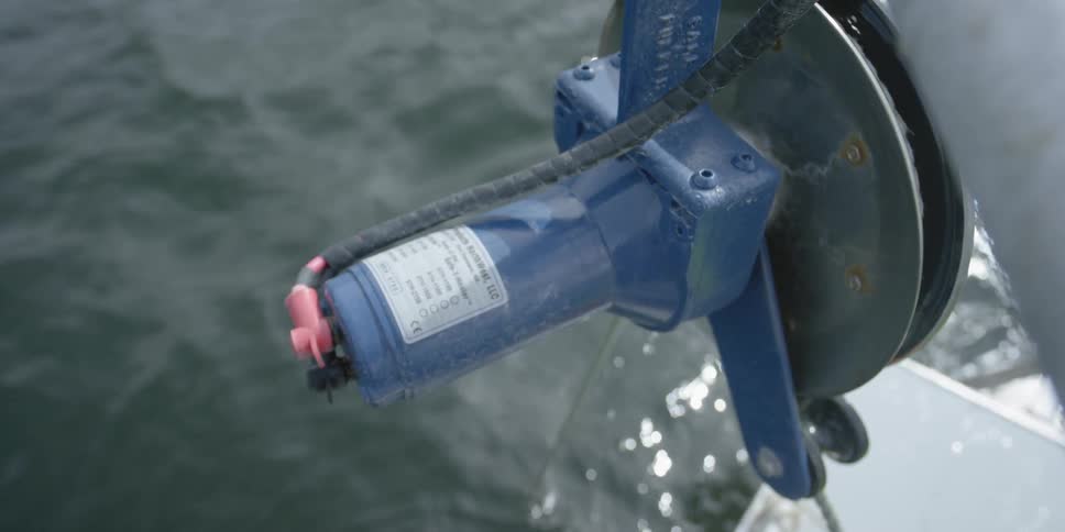 A pulley reels in a rope from the water