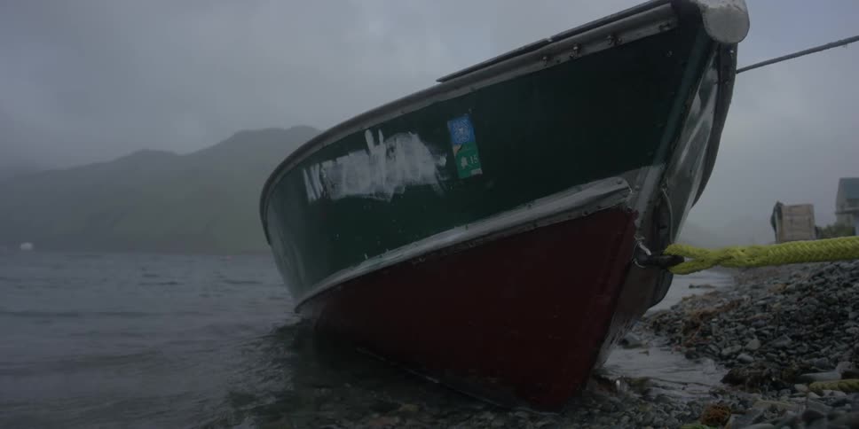 A boat rocks while docked on an overcast day