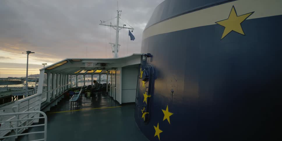 A flag blows in the breeze on a large ferry boat
