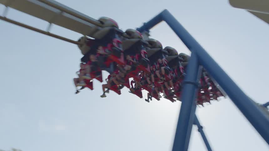 People ride on a rollercoaster in an amusement park
