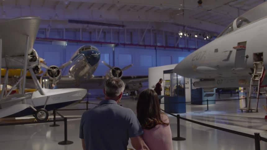 Man and woman look at airplanes in an indoor exhibit