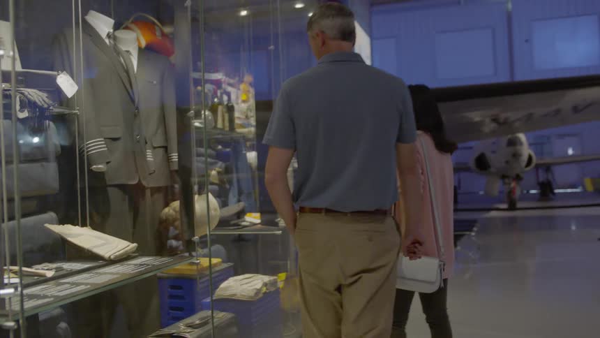A couple walk past a display in a museum