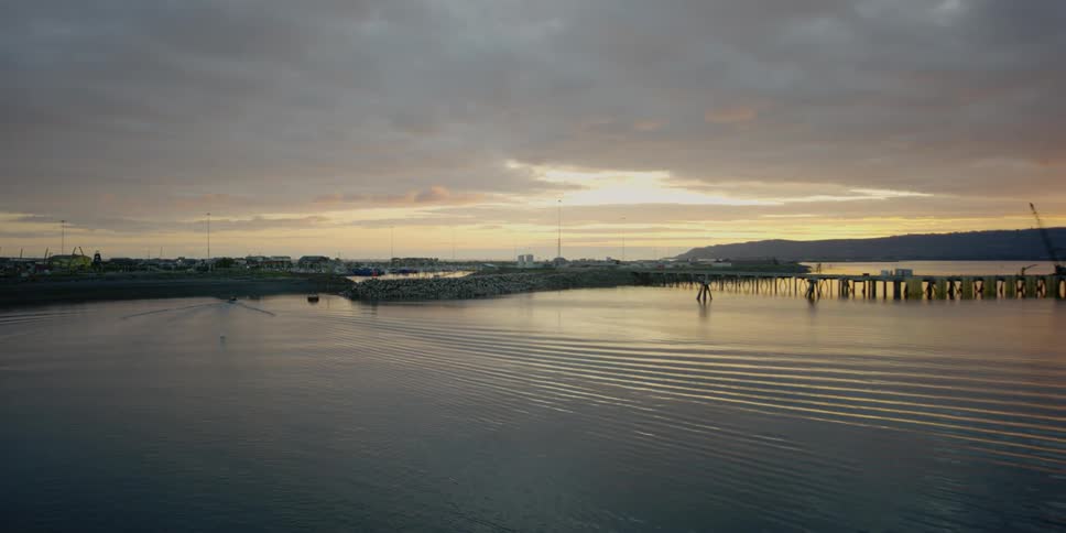 The sun is setting over the small pier