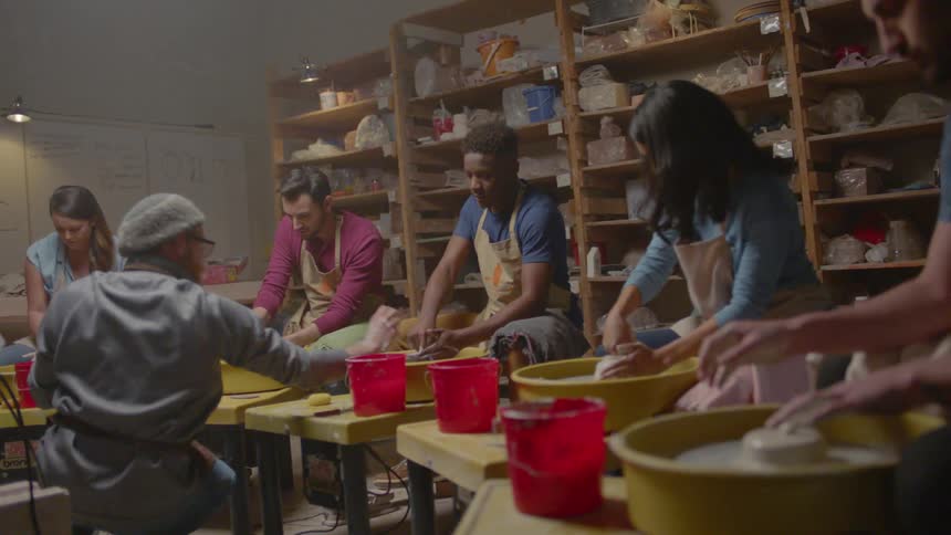 Several people take a pottery class