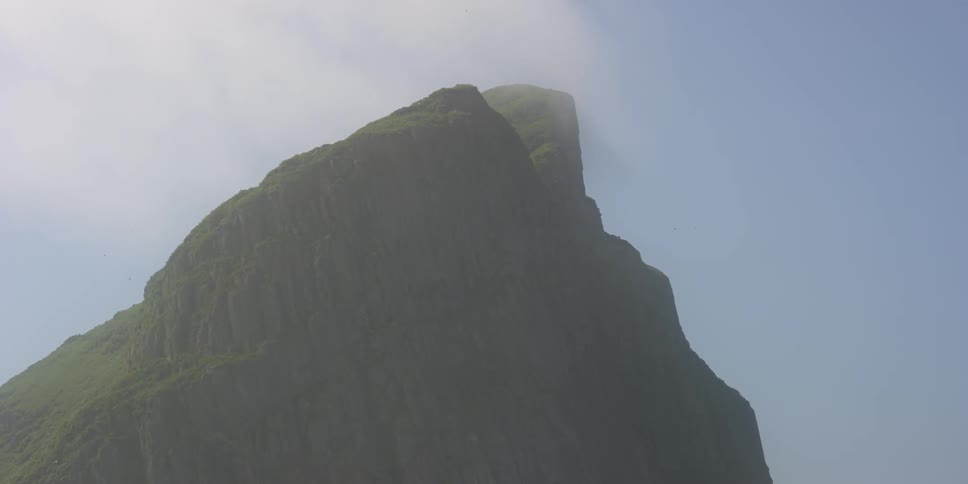 A tall rock mountain in the mist