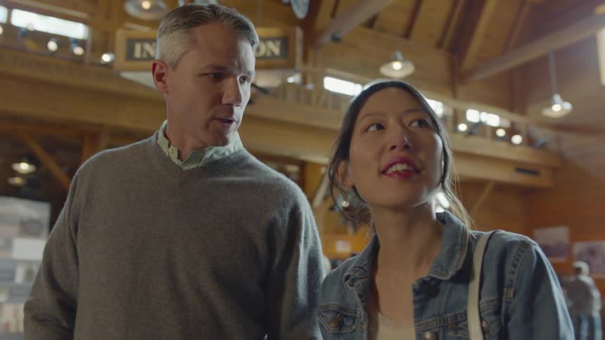 Man and woman hold hands inside a large building