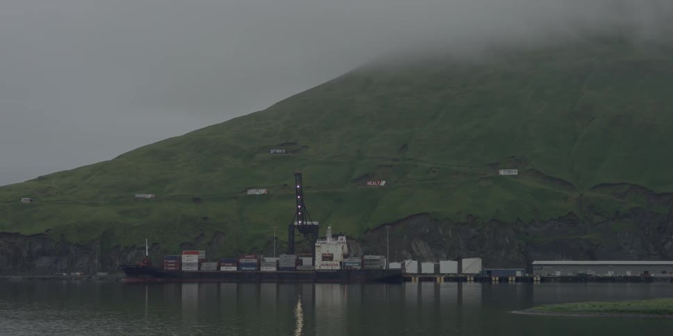 A ship sits at dock on a foggy day
