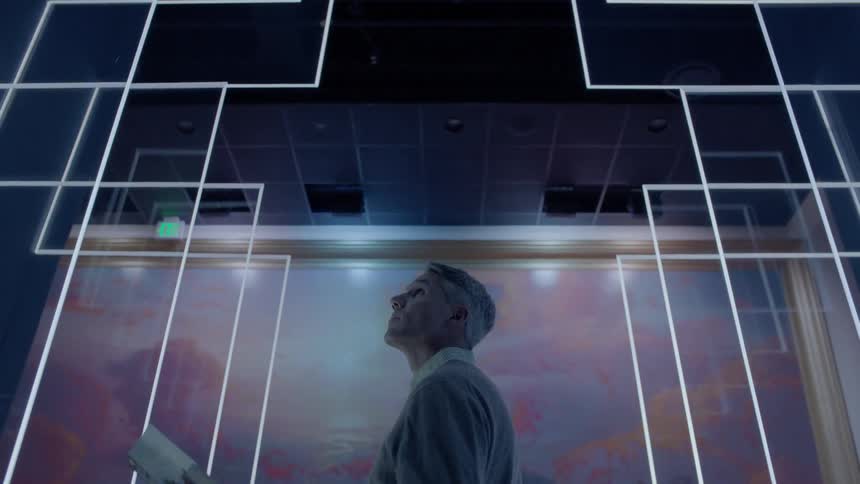 A man looks at a big piece of art on the wall