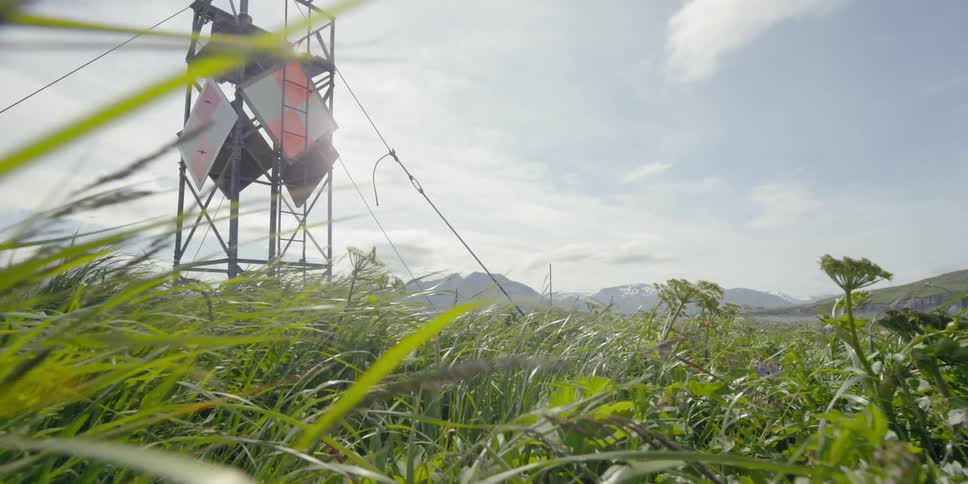 A metal tower in a grassy field