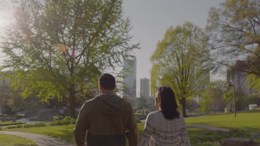 A man and woman walk through a path in the center of the city
