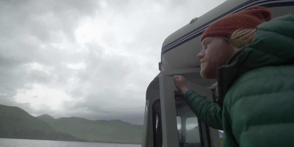 A man leans off a boat taking in the view