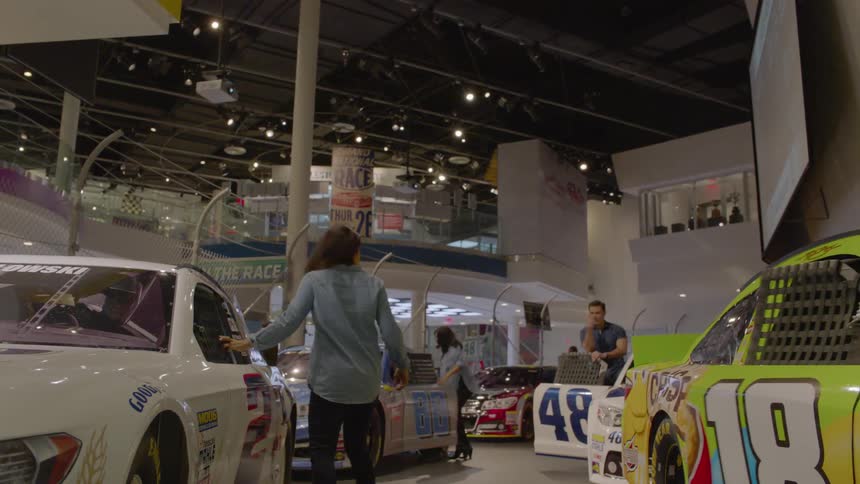 People run onto a racetrack and climb into race cars