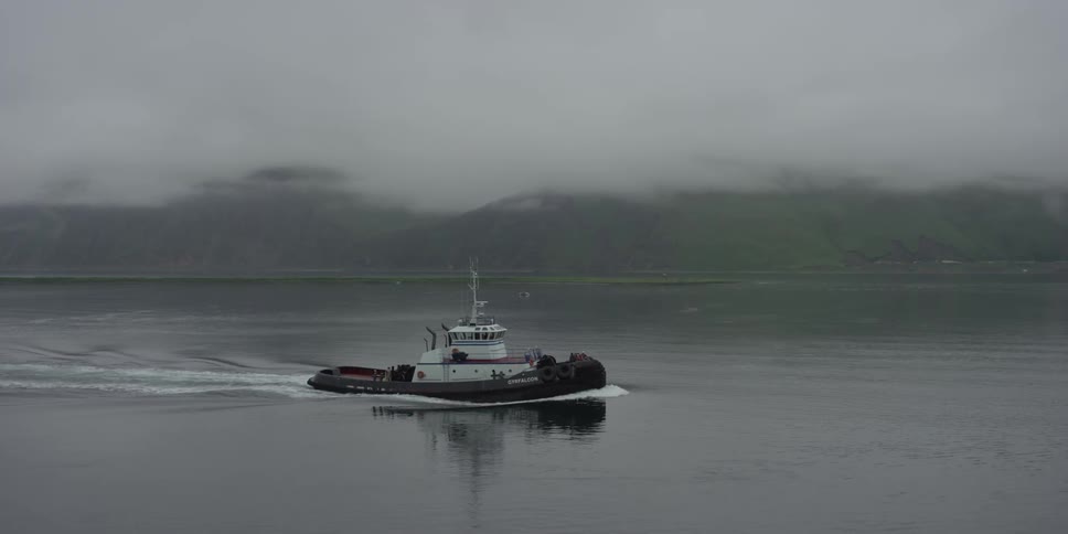 A boat floats on the sea on a misty day