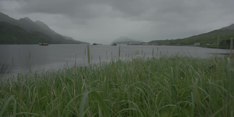 Boats float on the ocean on an overcast day