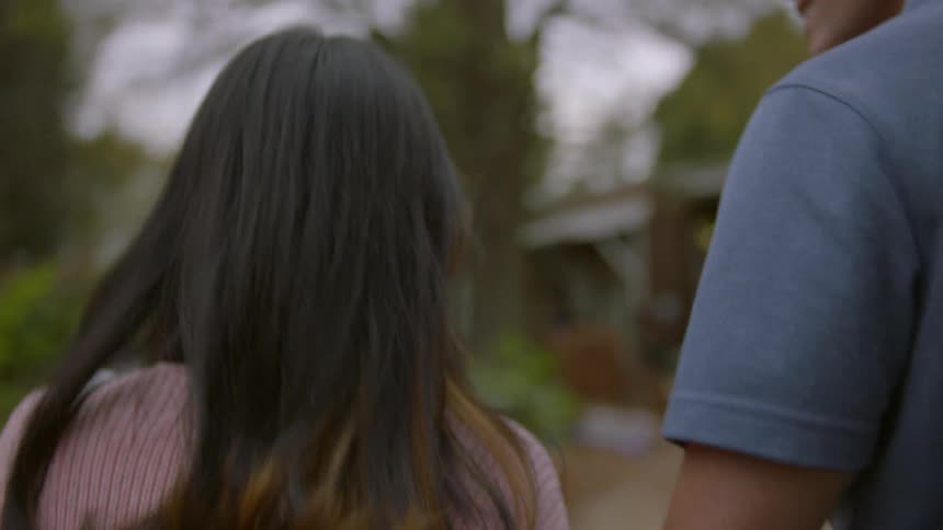 Couple smiling and walking together down a walkway