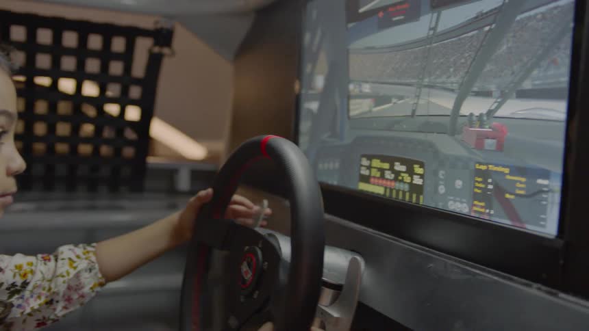 A young girl plays a racing video game