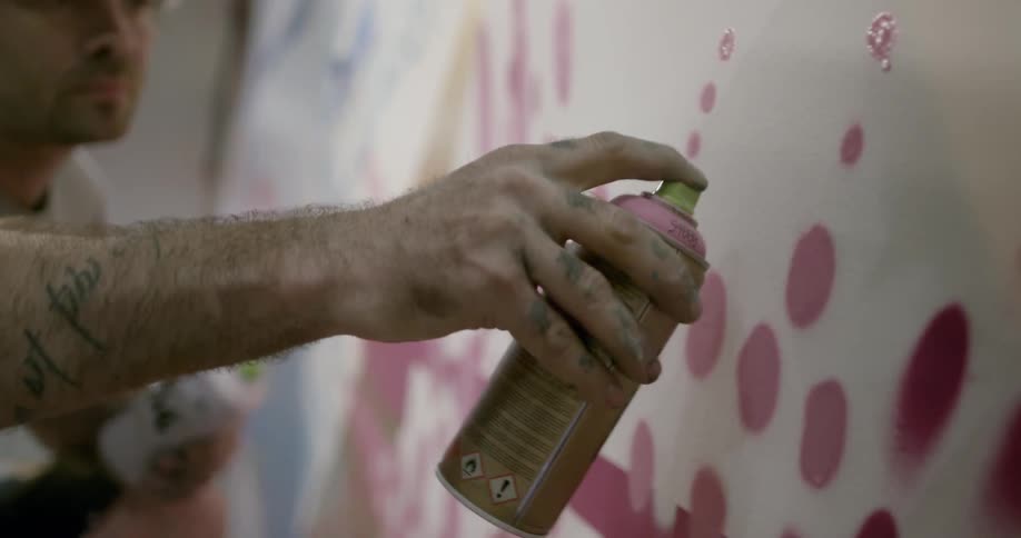 Man creates art with spray paint on a wall