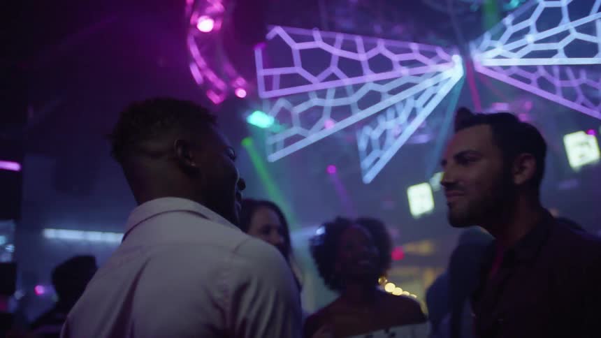 Two men dance together in a club