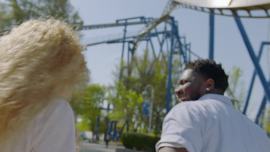 A couple walks through an amusement park