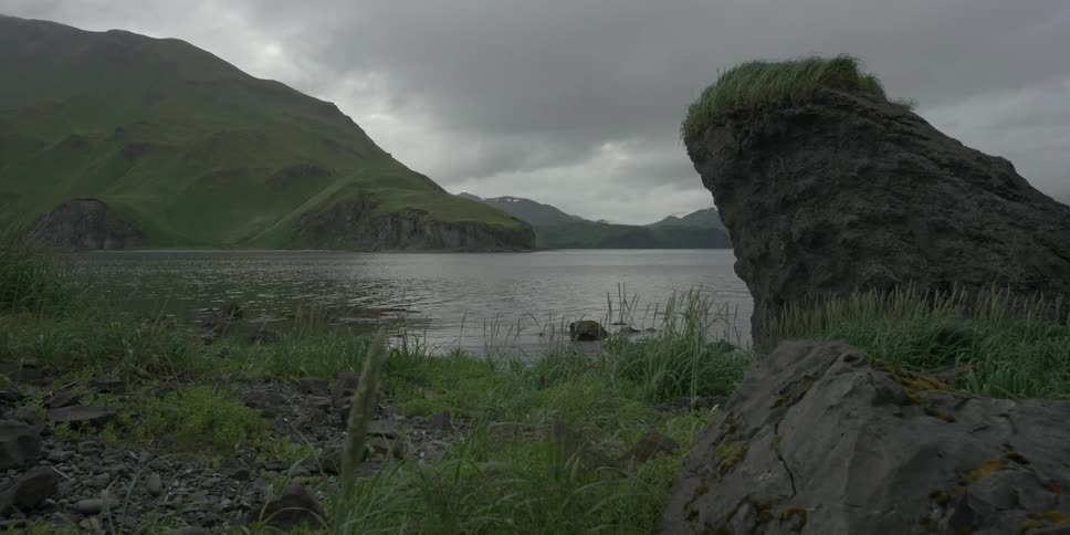 Storm clouds hang over a coastal mountainside