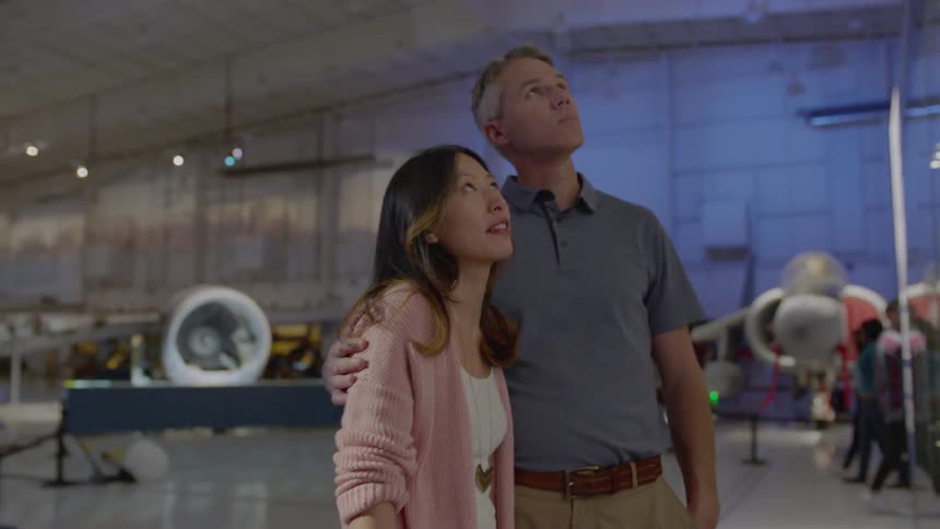 A couple are viewing an exhibit in an aviation museum