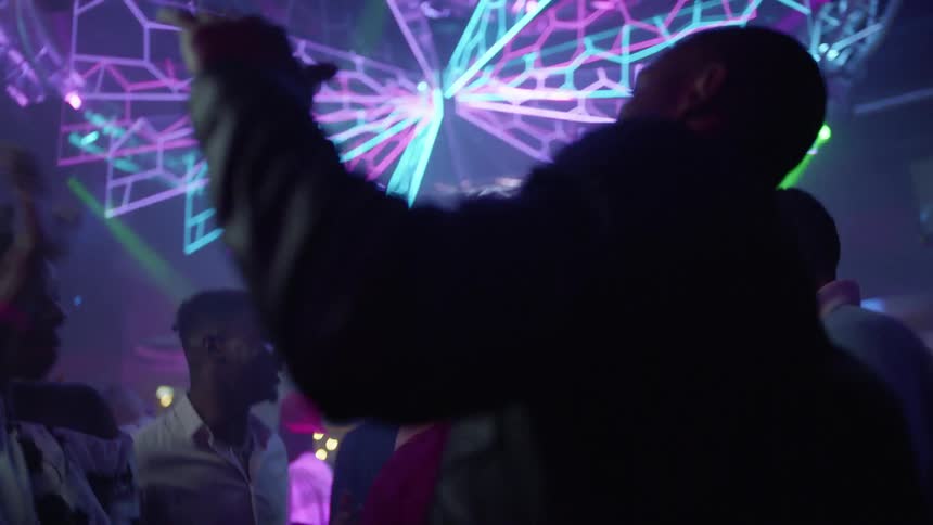 A bunch of people are dancing in a club