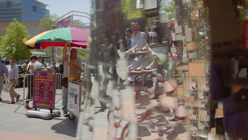 Pedestrians walk on a city sidewalk