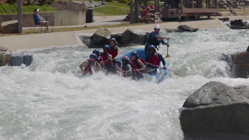 People are riding down the rapids on a raft