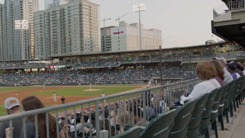Crowds of people in stadium watching baseball game