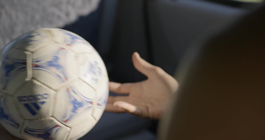 A person tosses a soccer ball between hands