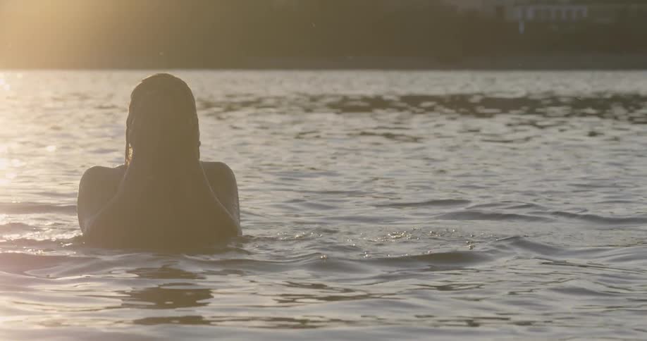 The man is moving around in the water of the lake