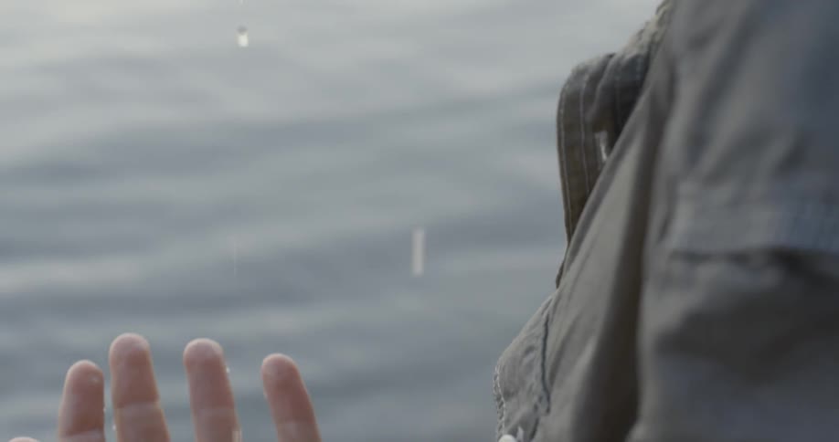 A person watches the water drip from his hair