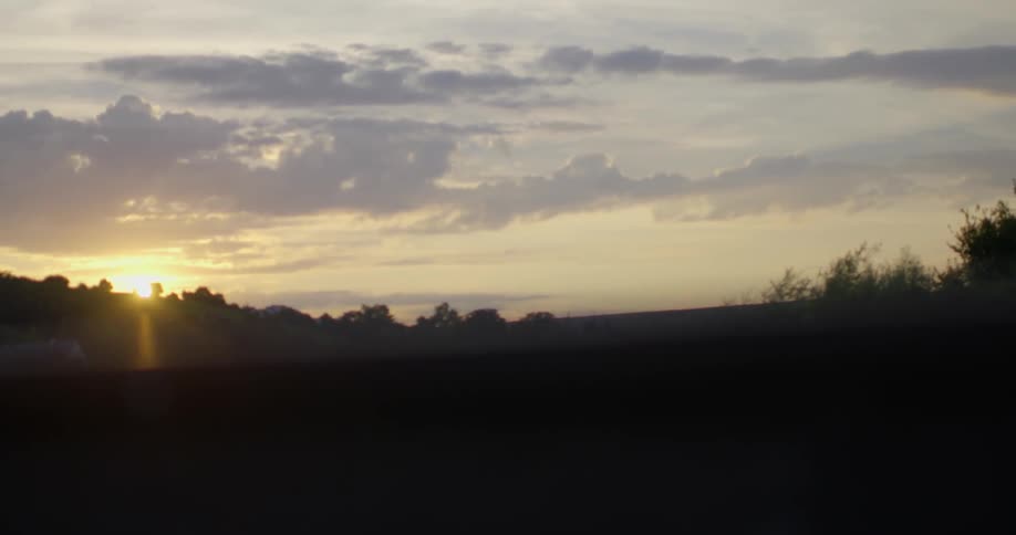 The sun sets behind a hill on the horizon