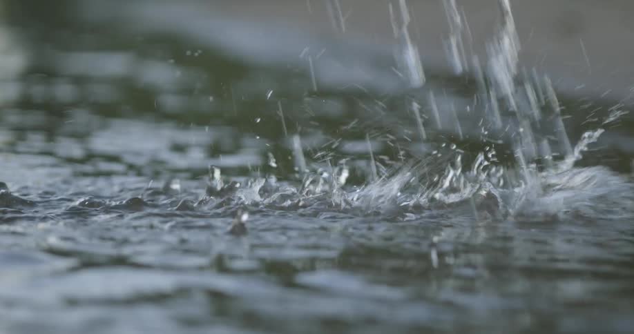 Water drips down onto the surface of the lake causing splashes