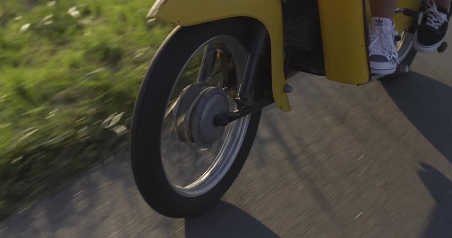 A yellow motorcycle traveling down the road