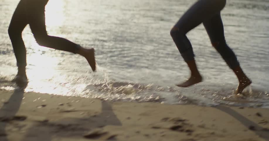 Women jog on a sandy shore