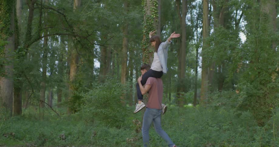 A woman is getting a piggyback through the forest
