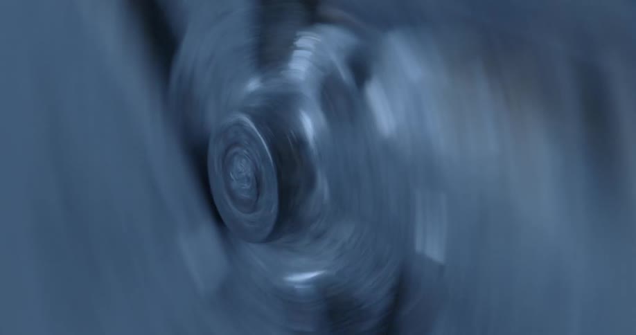 A silver piece of metal spins as if on a wheel