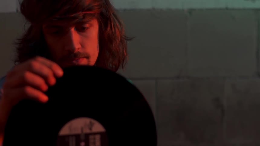 Man looks through stack of records and pulls one out