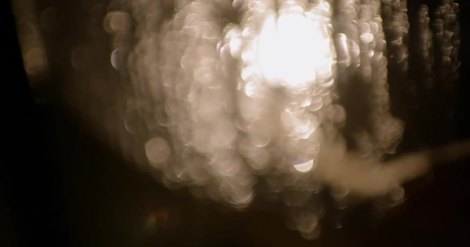 A person passes a hand over a window laden with condensation